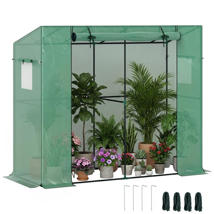 Green small walk-in greenhouse with roll-up door and clear front panels, outdoors