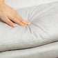 Light gray microfibre massage chair upholstery detail with hand-touching cushion