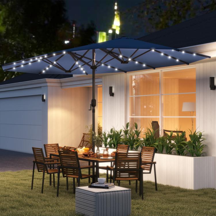 Blue patio parasol with LED lights strung along ribs over outdoor seating