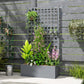 Gray raised planter box with tall trellis grid and mixed climbing plants