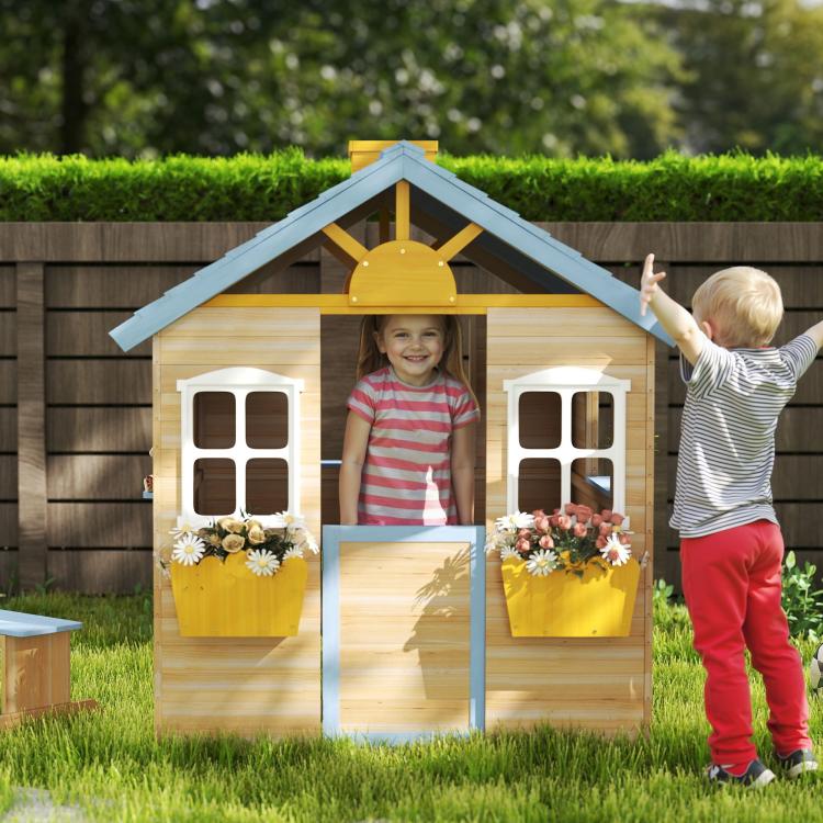 Outdoor wooden kids playhouse with blue roof, white windows, and front door with flower boxes