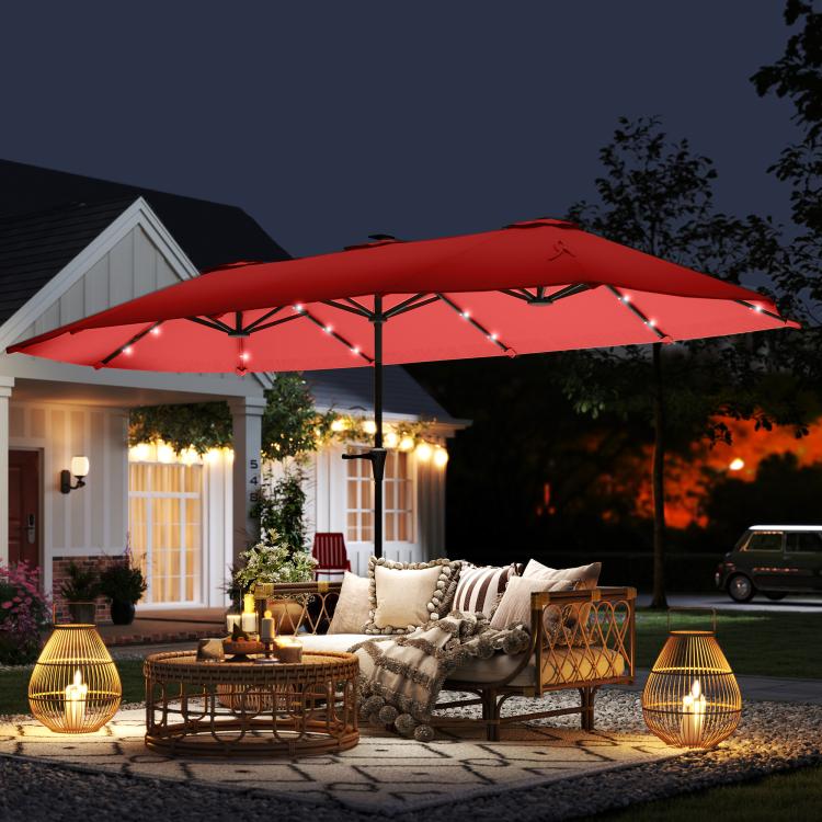 Wine red patio umbrella at night with glowing solar LED lights and porch seating