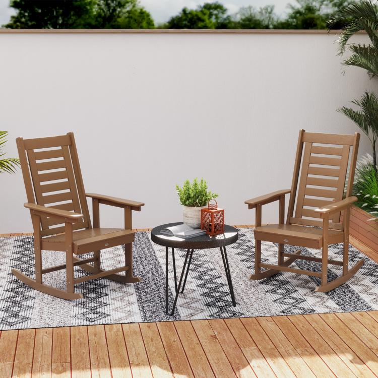 Two brown outdoor rocking chairs with high slatted backs and wide armrests
