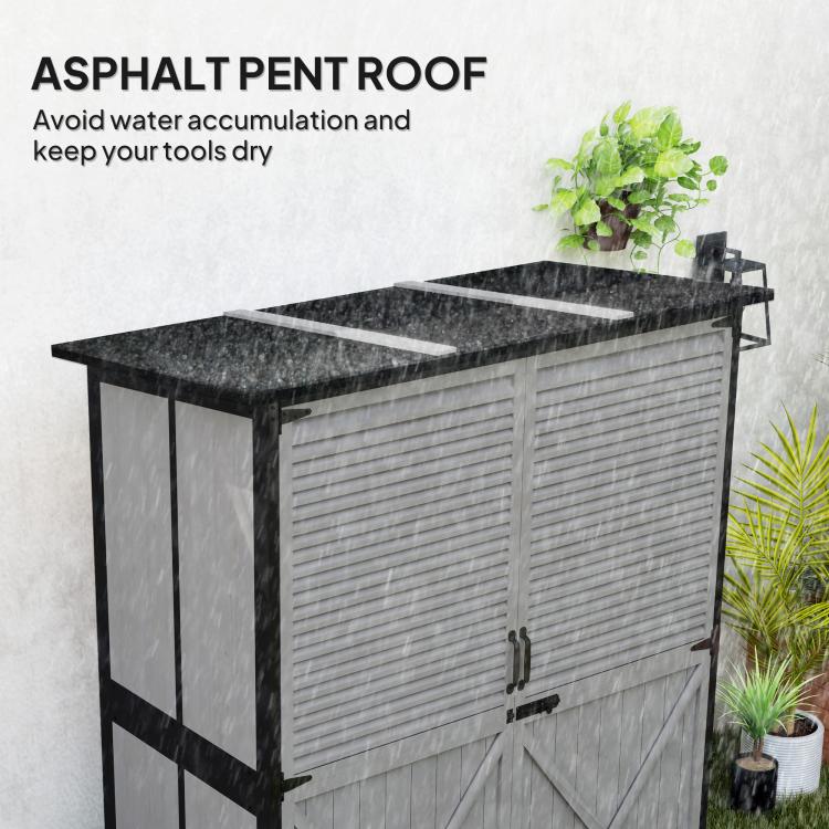 Gray storage shed exterior with black asphalt roof and double shutter doors