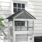 Gray wooden bird aviary with sloped roof and front wire mesh panels