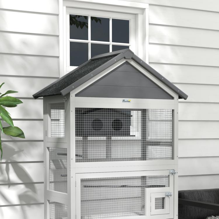 Gray wooden bird aviary with sloped roof and front wire mesh panels