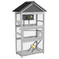 Gray wooden bird aviary with wire mesh, perches, and ladder under sloped roof