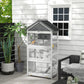 Gray wooden bird aviary with wire mesh walls and diagonal ladder