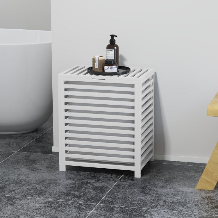 White slatted bamboo laundry hamper with lid holding soap bottles on top
