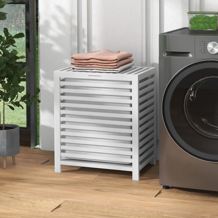 White slatted bamboo laundry hamper with lid holding stacked towels