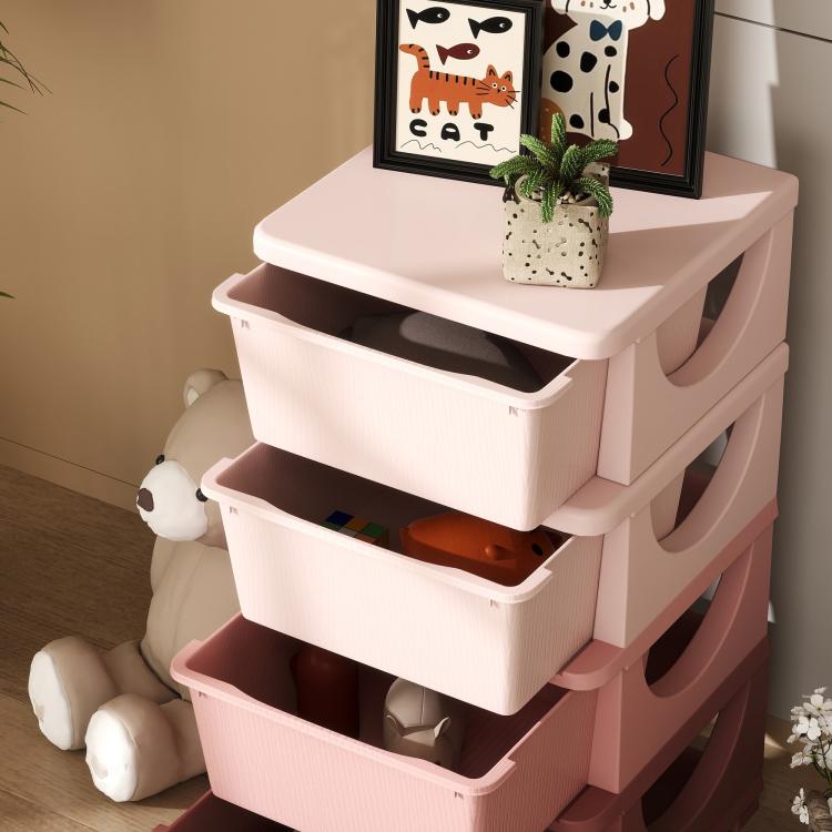 Pink kids dresser tower with three drawers open, stacked on a raised base