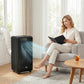 Black portable air conditioner with exhaust hose beside sofa and curtains