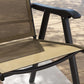 Close-up of folding patio chair seat and armrest, light mixed brown fabric on black frame