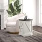 White side table with black top and storage door, holding a phone charging on top