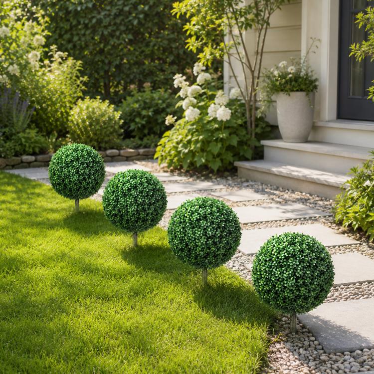 Cluster of artificial boxwood ball topiary trees with green foliage and ground stakes
