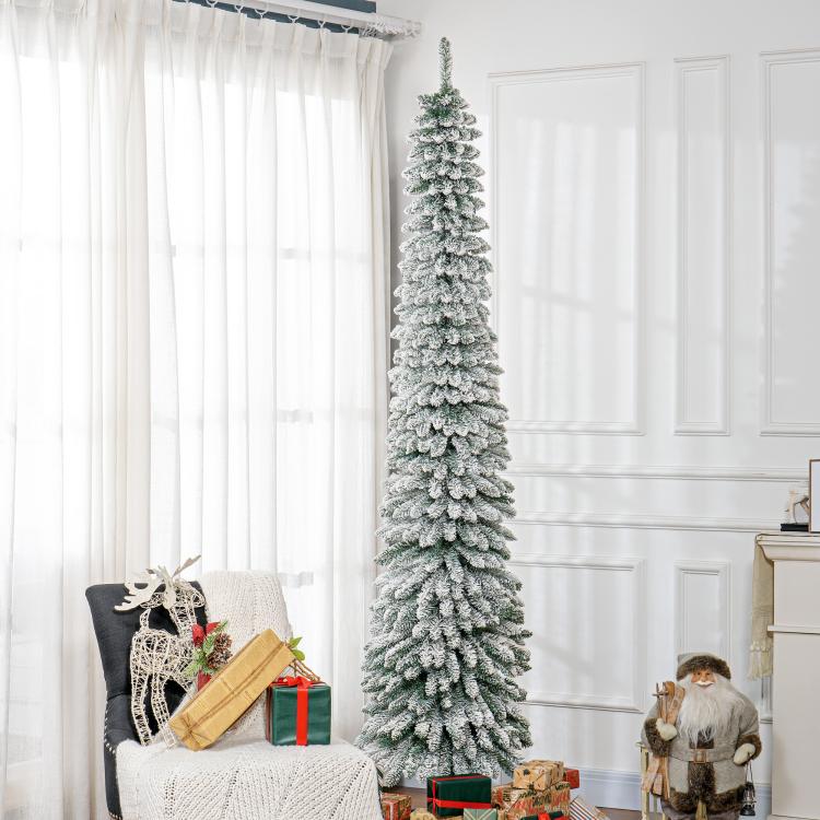 Snow-frosted slim artificial Christmas tree with dense branches, upright on stand