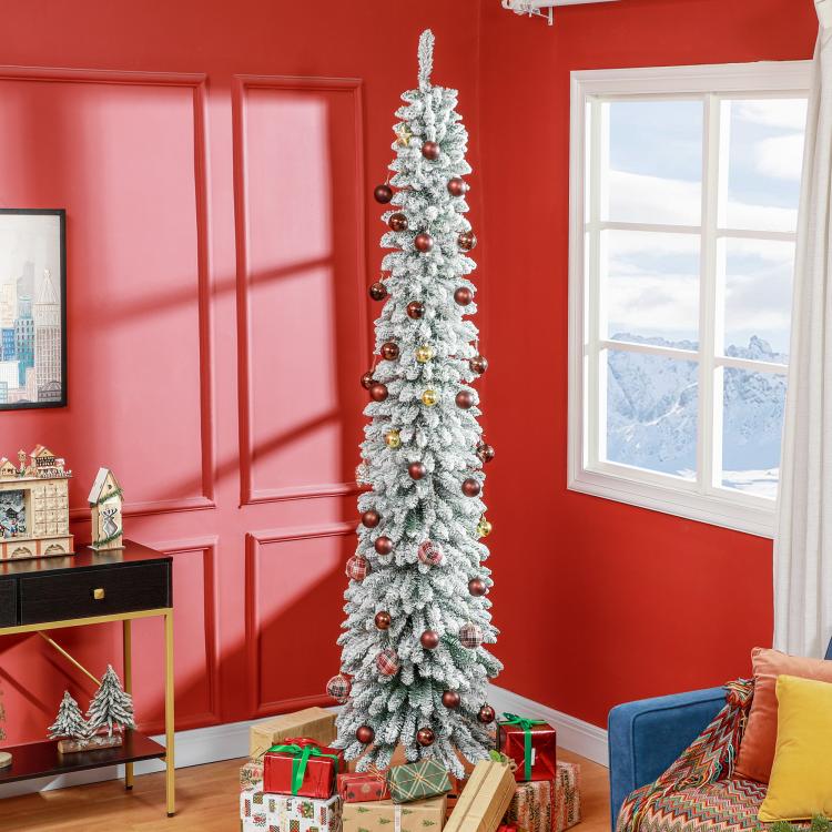 Snow-frosted slim artificial Christmas tree with red ornament accents, upright on stand