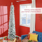 Snow-frosted slim artificial Christmas tree, upright on metal stand