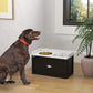 Pet feeding station with two metal bowls and storage drawer, in use with a dark dog