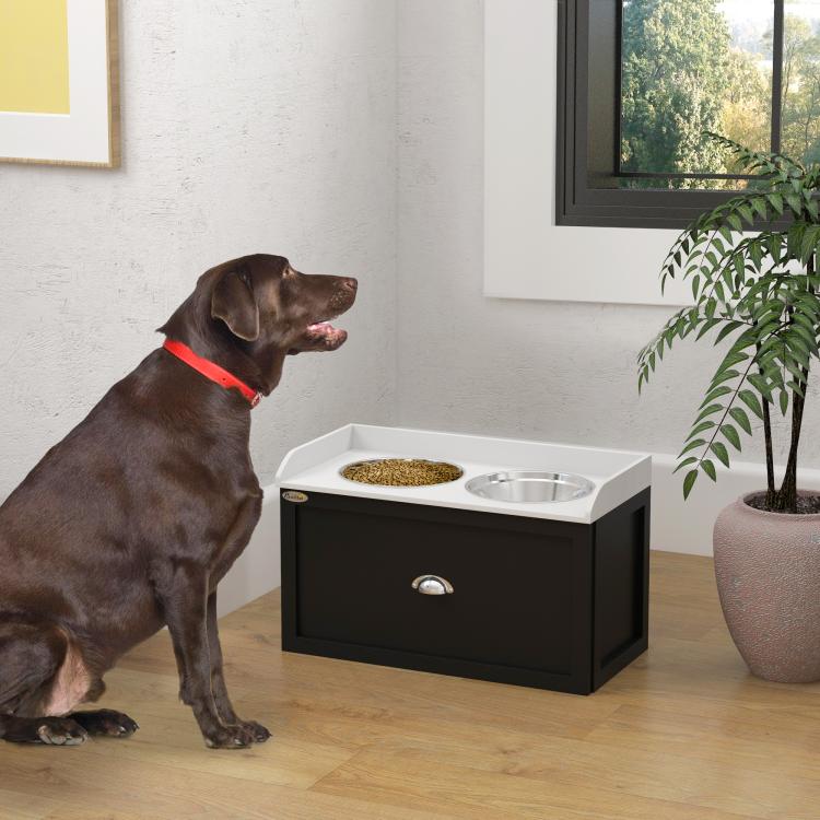 Pet feeding station with two metal bowls and storage drawer, in use with a dark dog
