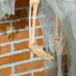 White tattered hanging ghost prop with long fabric legs and orange pumpkin face hood