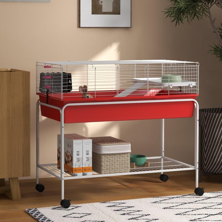Two-story small animal cage in red with wire walls and lower storage shelf on wheels
