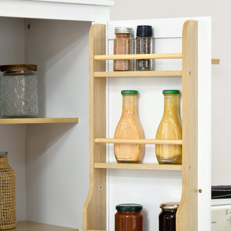 Wood spice rack inside white pantry cabinet holding glass jars and bottles