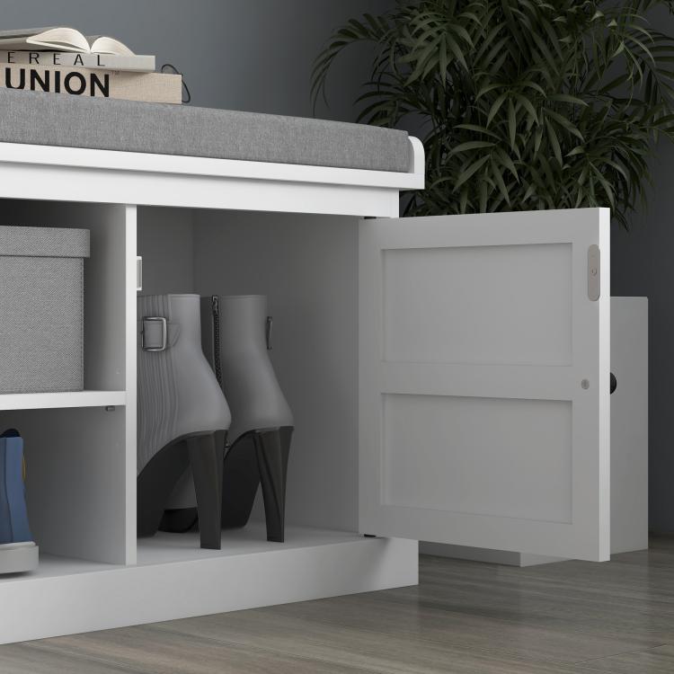 White entryway shoe storage bench with gray cushioned top; open cabinet doors reveal shelves