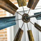 Windmill weather vane hub with dark-blue metal blades and metal arms