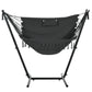 Dark gray hammock chair with headrest pillow and fringe, supported by U-shaped stand