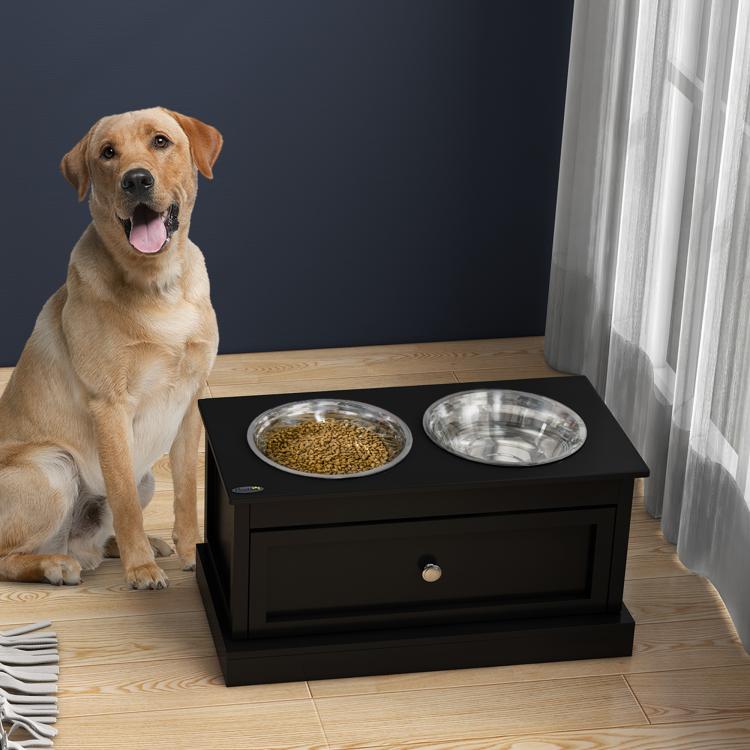 Black storage dog bowl stand with two stainless steel bowls and dog beside it