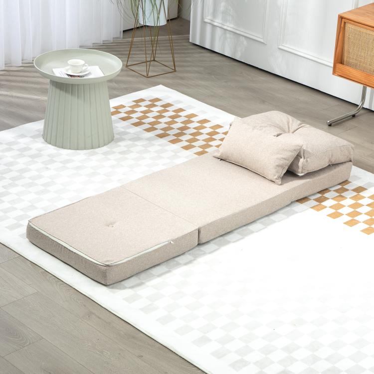 Beige sofa bed laid flat with two cushions on the floor