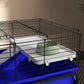 Two-story small animal cage with blue stand, removable clear shelf, black wire enclosure