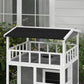 Light gray wooden cat house with black asphalt roof and enclosed balcony with circular holes