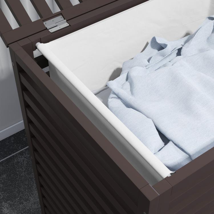 Dark brown bamboo laundry hamper with slatted sides and open top holding light cloth