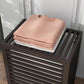 Coffee bamboo laundry hamper top with stacked folded towels on slatted lid