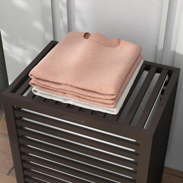 Coffee bamboo laundry hamper top with stacked folded towels on slatted lid