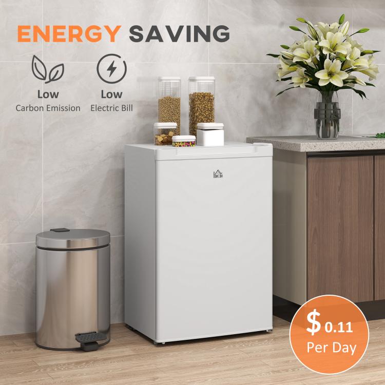 White upright freezer near a kitchen counter with flowers on top