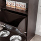 Close-up of gray pet feeder cabinet interior with open tray and raised stainless bowls