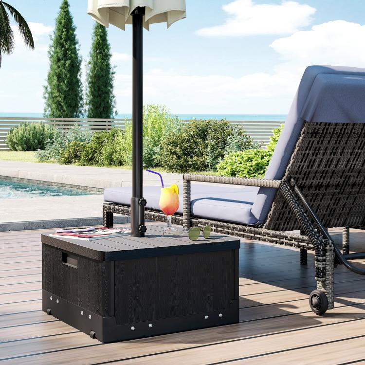 Black umbrella base table with wood-look top and storage drawer on patio deck