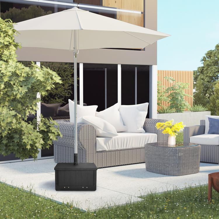 Black outdoor umbrella base table under shade with wood-look surface and storage drawer