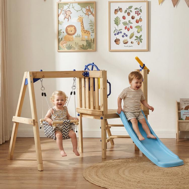 Indoor view of wooden swing set with blue slide and hanging rope swings