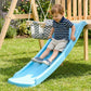 Child riding blue slide from wooden swing set with hanging swing ropes