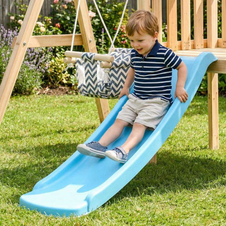 Child riding blue slide from wooden swing set with hanging swing ropes