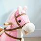 Close-up of pink plush rocking horse head with brown bridle and round black eye