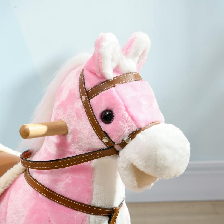 Close-up of pink plush rocking horse head with brown bridle and round black eye