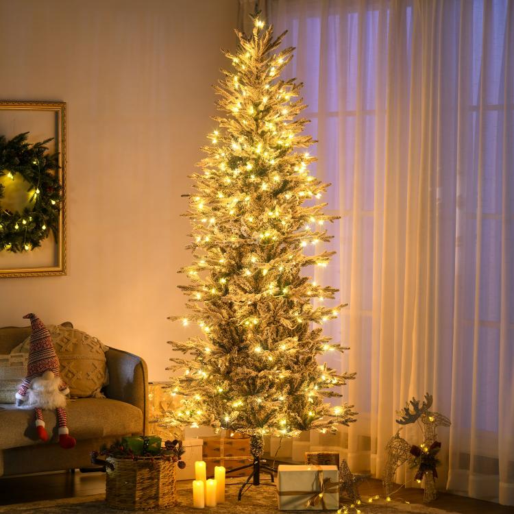 Flocked artificial Christmas tree with warm yellow clear lights, ready to display