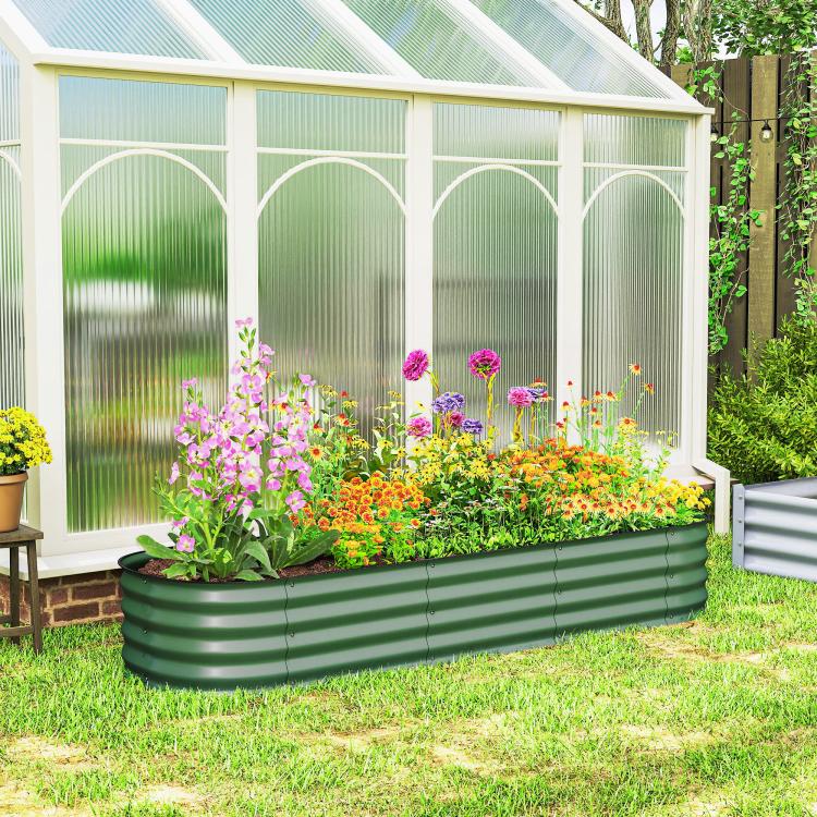 Green metal raised garden bed planter with safety edging, outdoors with flower plants
