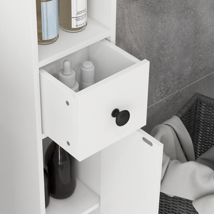 White narrow bathroom storage cabinet with pull-out drawer, open shelf, and black knobs