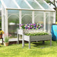 Gray raised garden bed planter with purple and white flowers in a sunny backyard